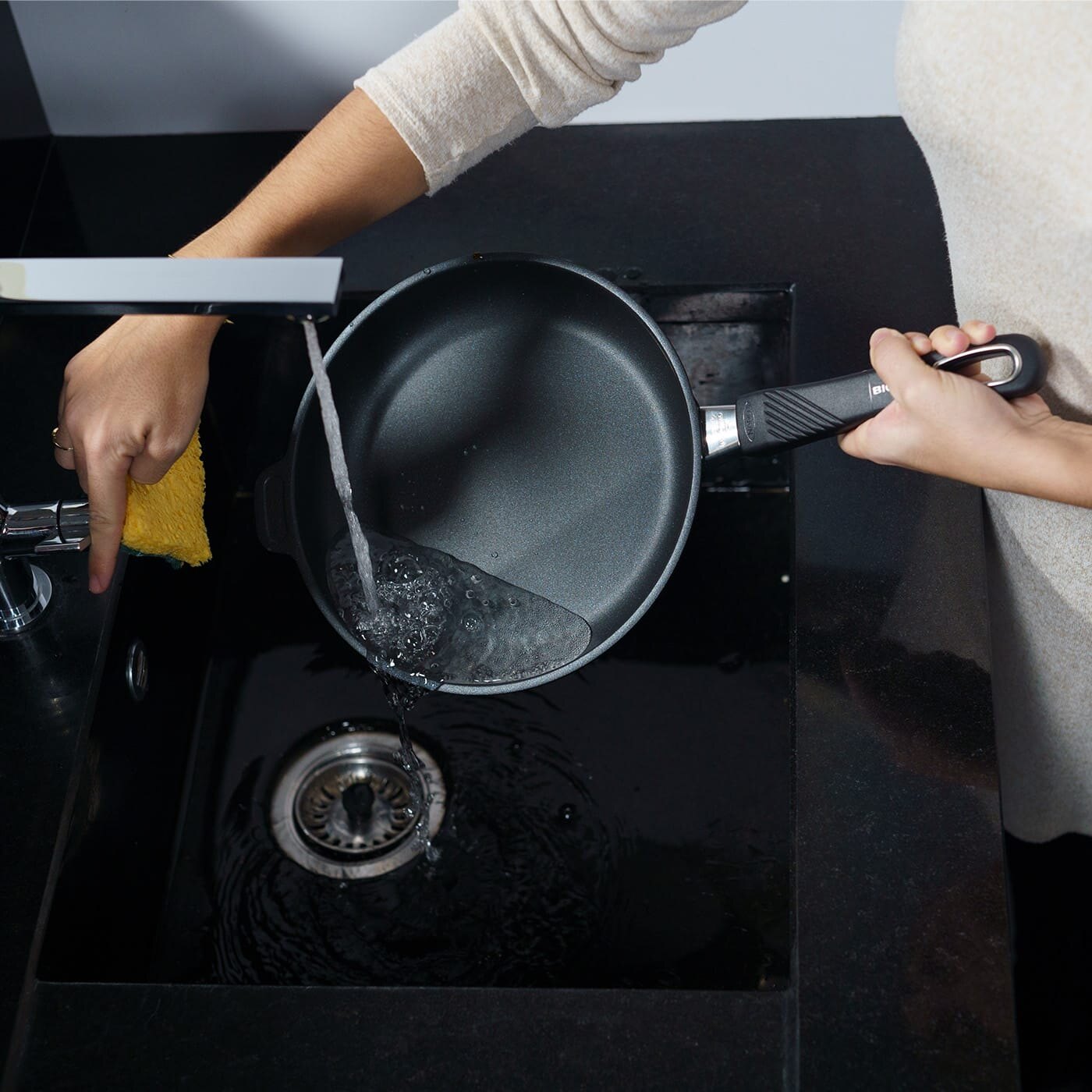 En person vasker en stekepanne.