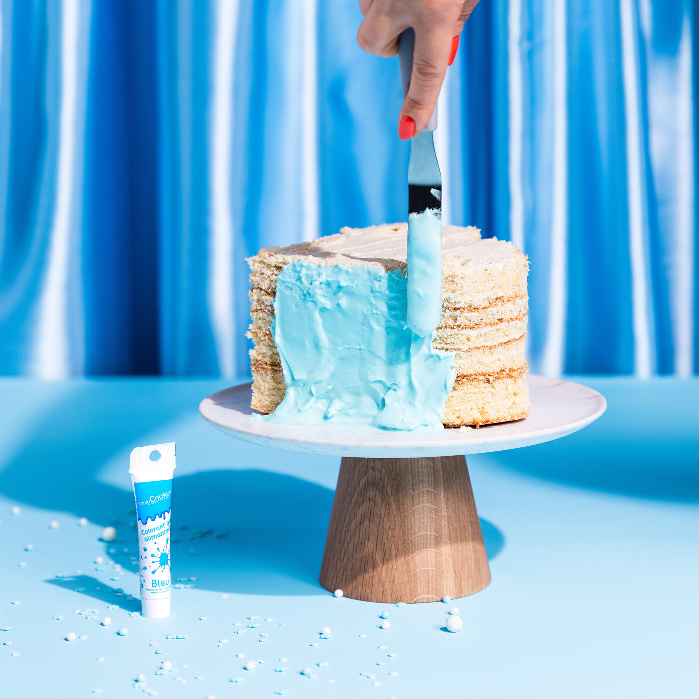 Blå glasur smøres på en kake