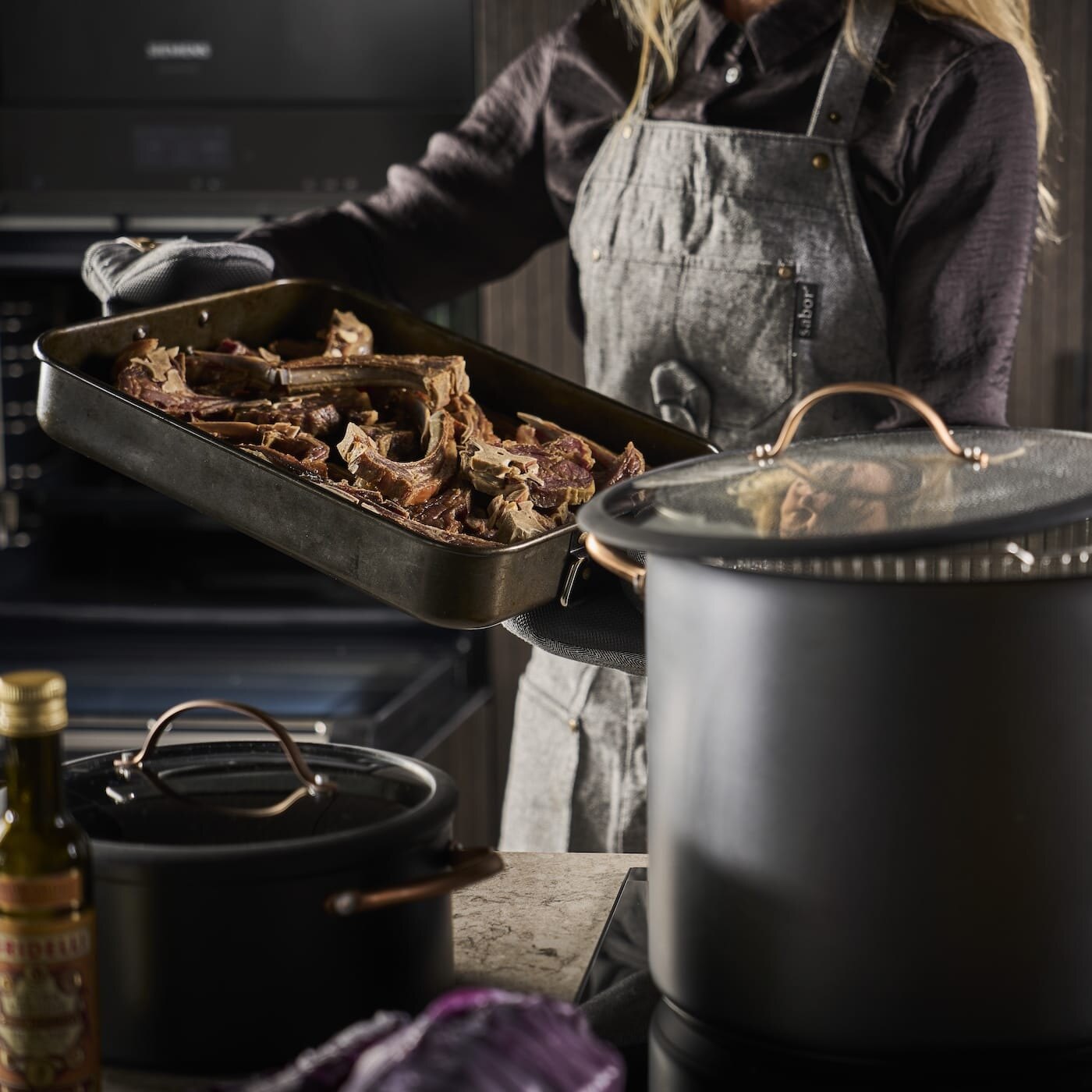 Dame holder stekebrett med pinnekjøtt i