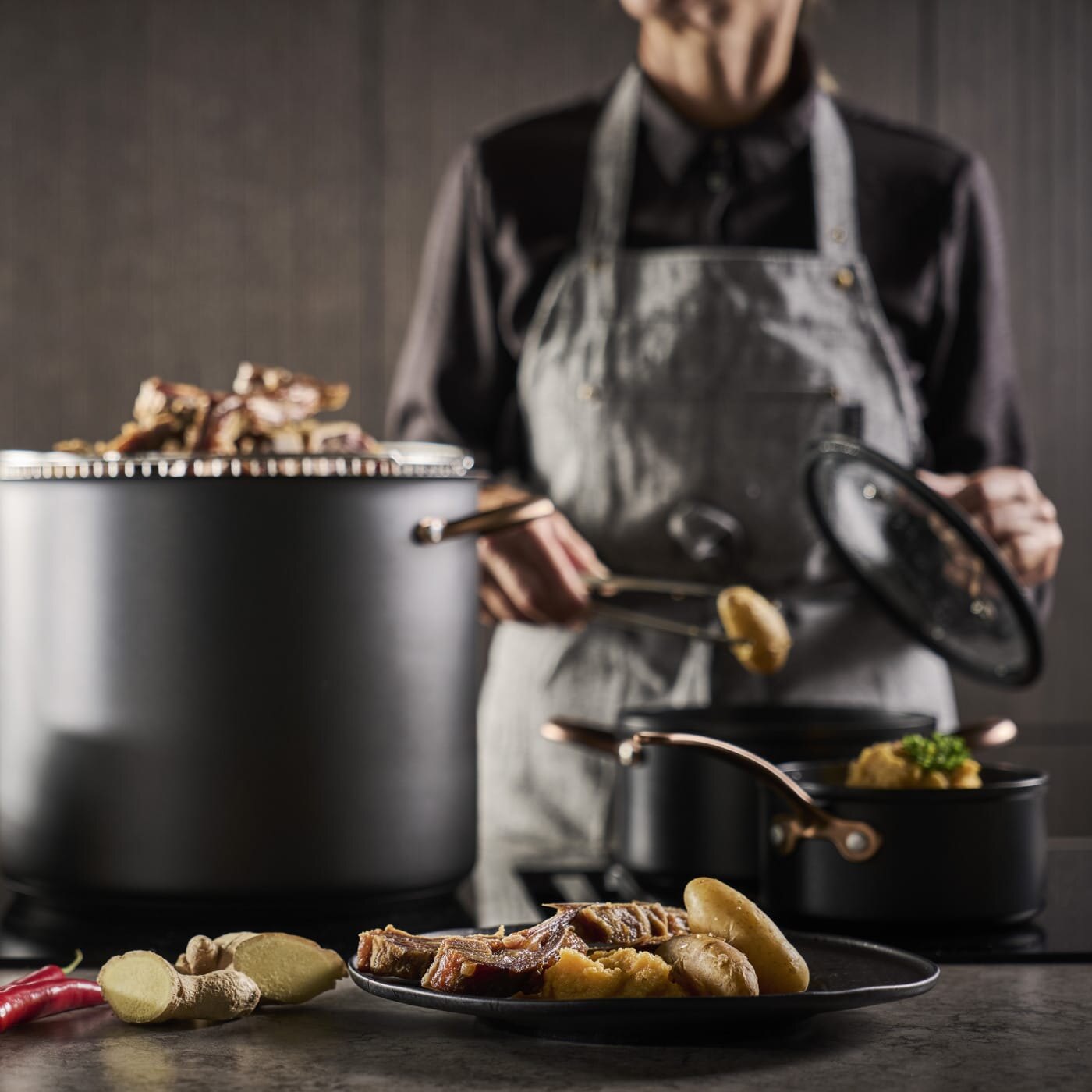 Dame legger opp pinnekjøtt fra gryte til tallerken