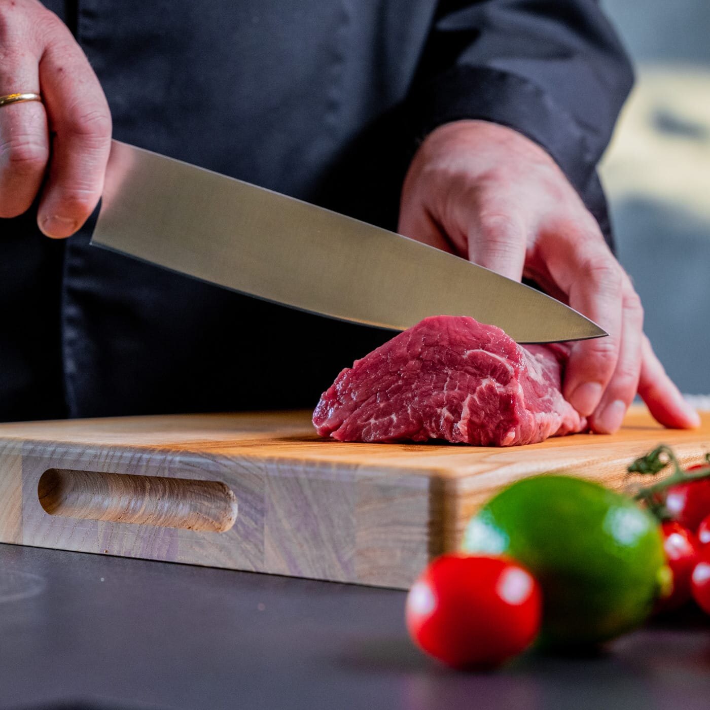 Mann skjærer kjøtt med Brusletto kniv på trefjøl