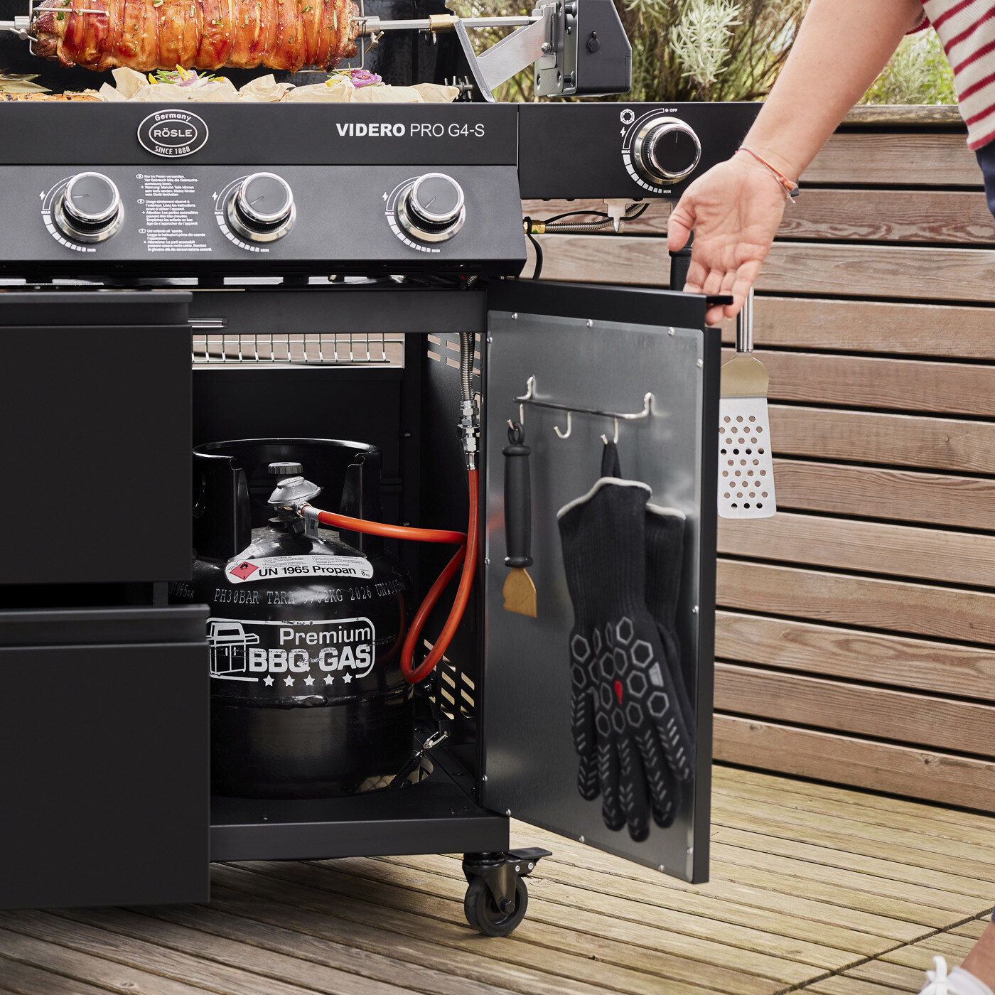 Mann sjekker gassflaske under grillen