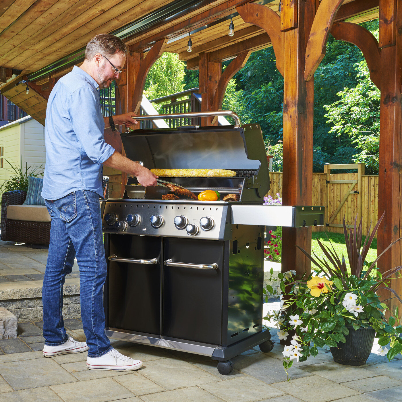 Mann griller p&aring; en grill fra Broil King