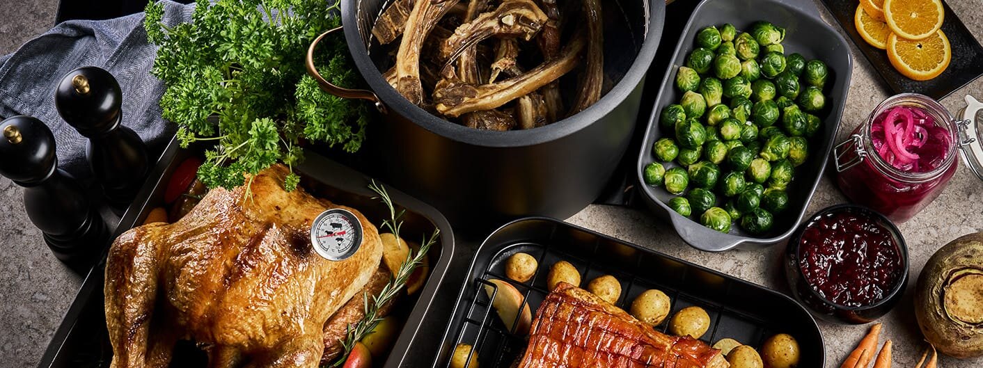 Bord med ferdig tilberedte retter av kalkun, pinnekjøtt, ribbe og tilbehør til julemiddagen, utstilt i produkter fra Modern House og Sabor.